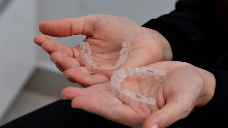 Hands holding clear dental aligners in a modern dental office in Belo Horizonte.