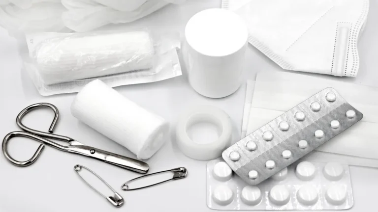 A flat lay of essential first aid supplies and medical equipment on a white background.
