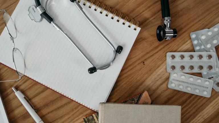 Flat lay of medical tools and supplies on a wooden desk surface.